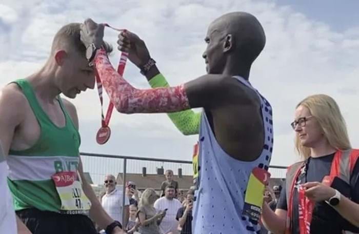 Tom Gostelow receiving Great North Run medal from Mo Farah